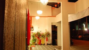 A hallway with chandeliers, a red curtain, and potted plants. - Old Penang Hotel - Penang Times Square (George Town)