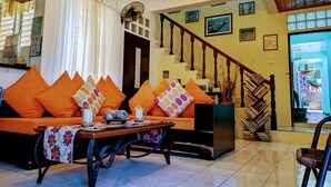 Sala de estar com sofá, mesa de centro e escada que leva a um andar superior.
