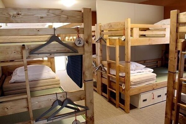 Bunk beds with wooden frames, a hanging coat rack, and a small storage cabinet.