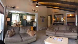 A spacious living room with two sofas, a coffee table, and a dining area with a table and chairs.