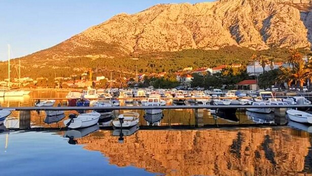 A marina with boats docked in calm waters, a mountain in the background, and a clear sky. - Apartments Clementina Sunrise - Studio with Balcony (Orebic)