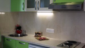 A kitchen with green cabinets, a white dishwasher, and a stainless steel range hood. - Apartments Clementina Sunrise - Studio with Balcony (Orebic)