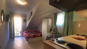 A compact kitchen with a stove, sink, and a small dining area. - Apartments Clementina Sunrise - Studio with Balcony (Orebic)