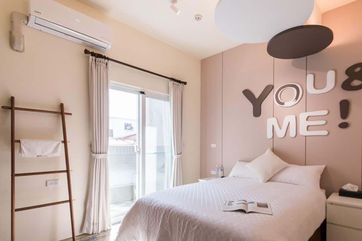 A modern bedroom with a bed, a ladder, a wall-mounted air conditioner, and a window with curtains.