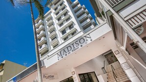 Un immeuble à plusieurs étages, doté de balcons et d’une enseigne indiquant « Madison on Abbott ».