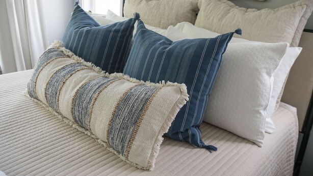 A bed with multiple pillows and a textured blanket. - Pool/Spa, guesthouse in the heart of ATX (Austin)