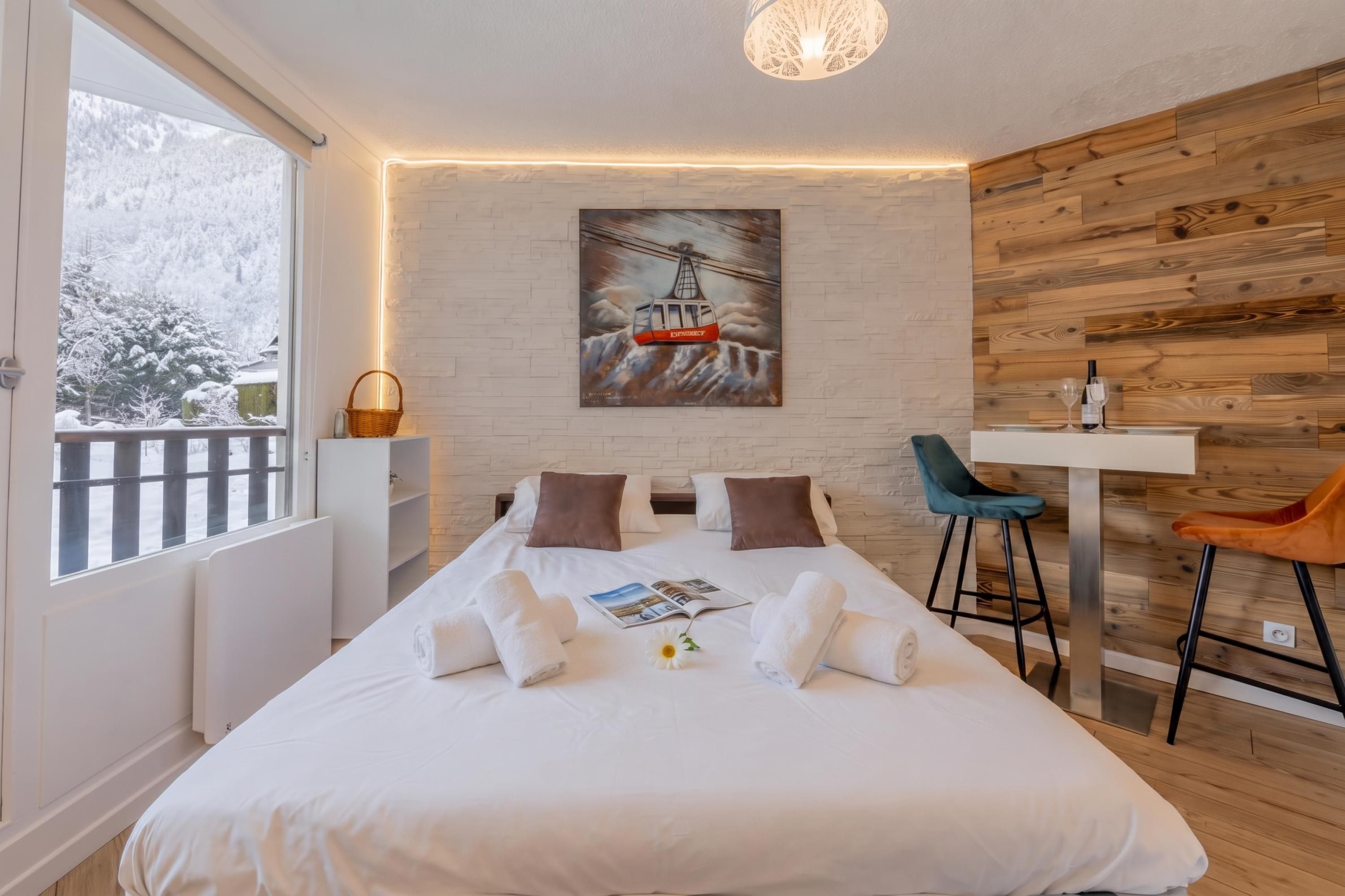 Ein Hotelzimmer mit Bett, einem Gemälde, einem Schreibtisch und einem Sessel.