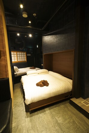 A hotel room with two beds, a wooden headboard, and a traditional Japanese shoji screen. - HOTEL Lee (Tokyo)