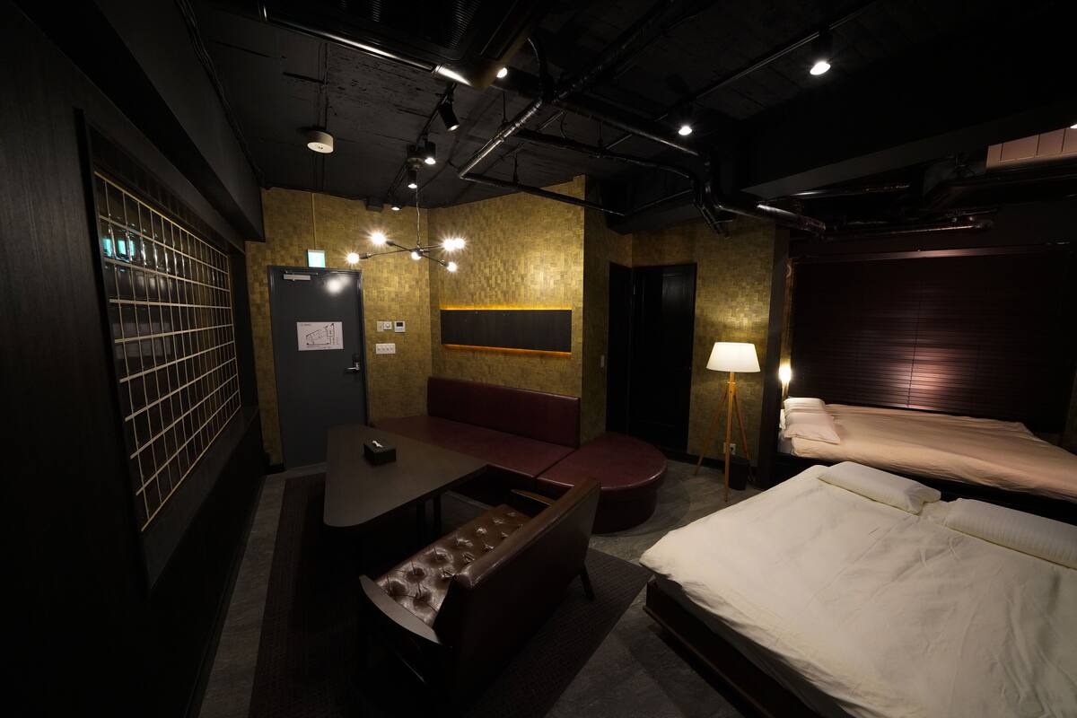 Habitación de hotel con cama, escritorio, banqueta y televisión montada en la pared.