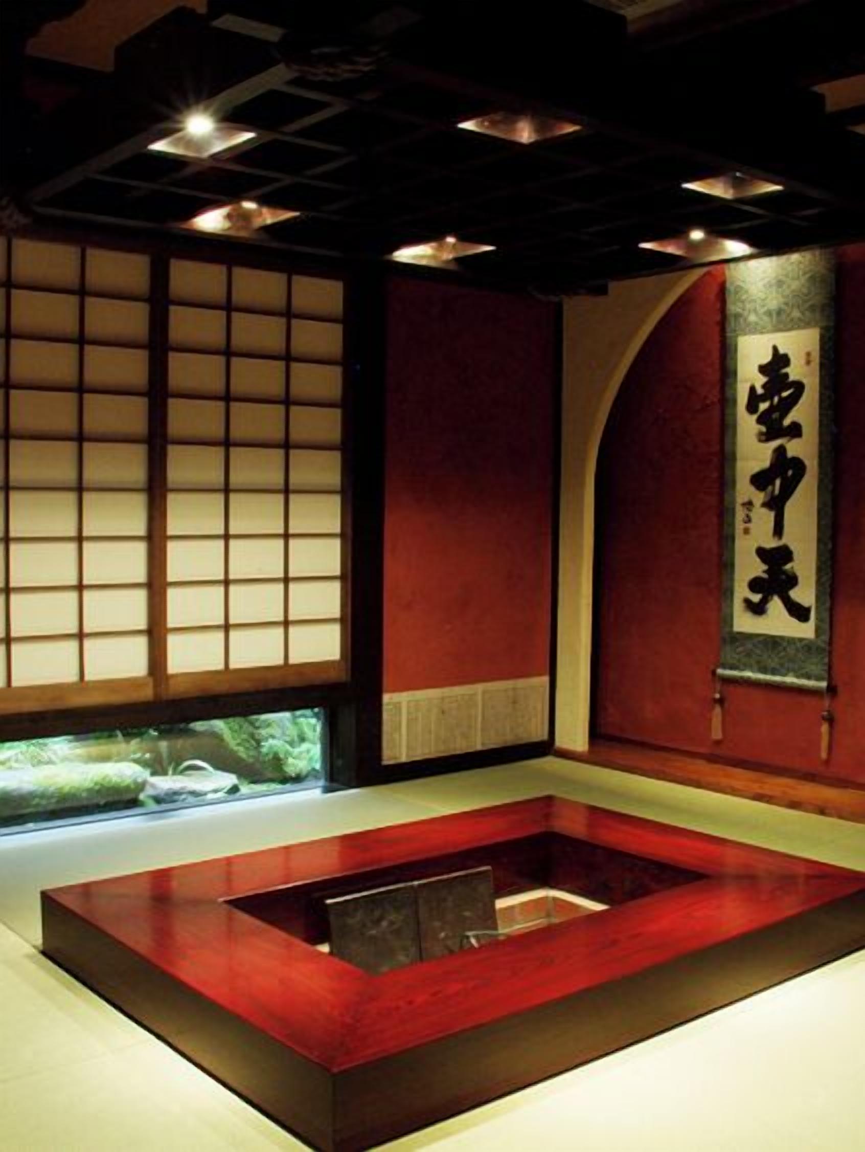 A traditional Japanese room with tatami flooring, a low wooden platform, and a sliding door with calligraphy.