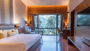 Una habitación de hotel moderna con una cama grande, un escritorio, una silla y un televisor.