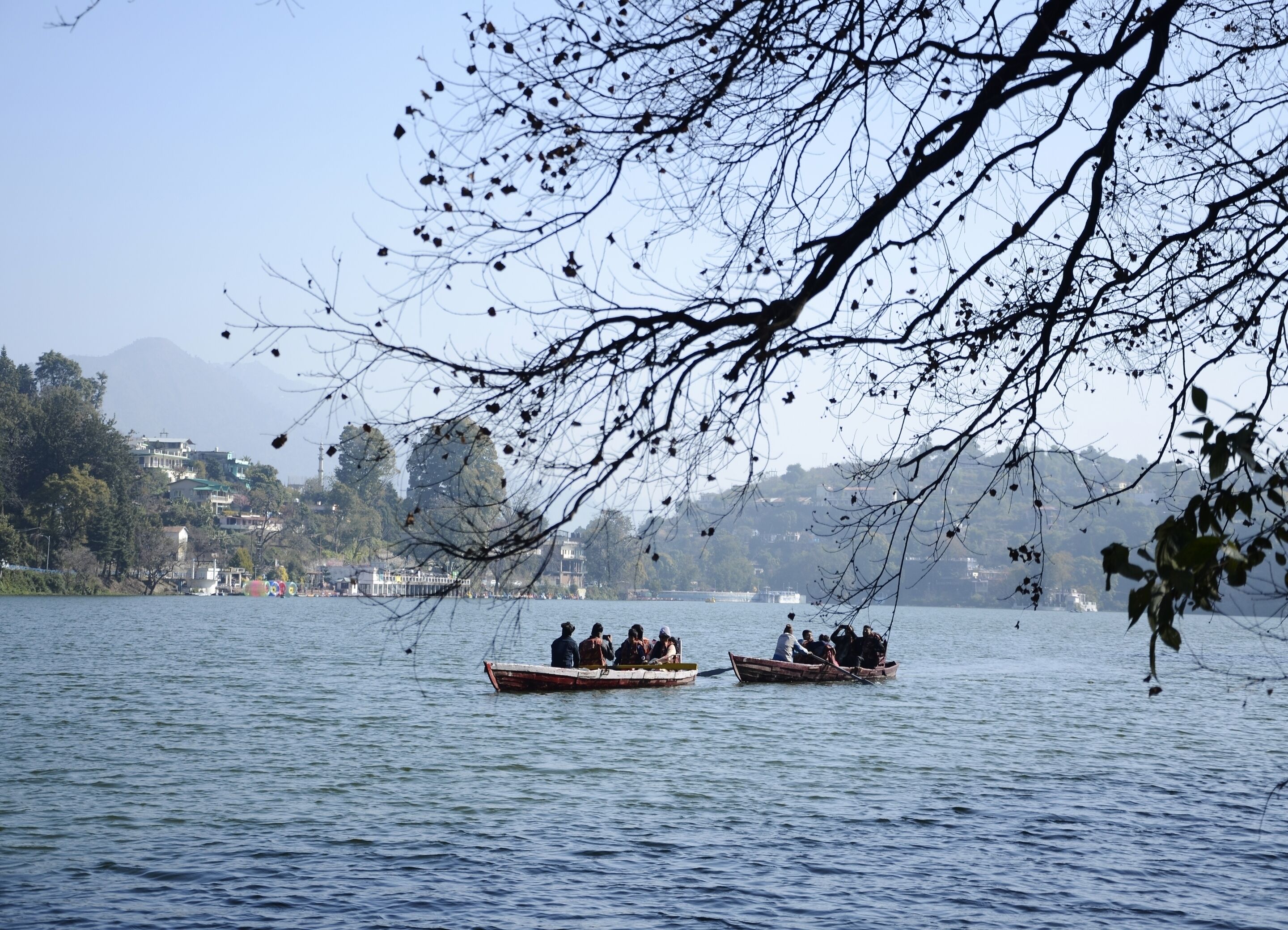 A lake with boats and a distant shoreline with buildings.