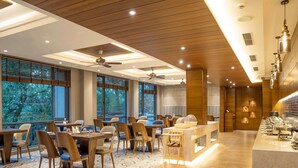 Un comedor moderno con suelo de madera, ventanas amplias y ventiladores de techo.
