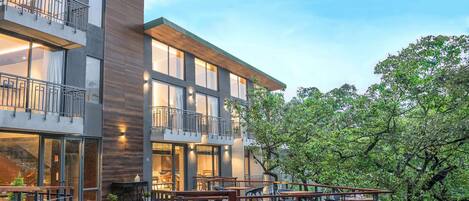 A modern building with multiple balconies and outdoor seating areas.