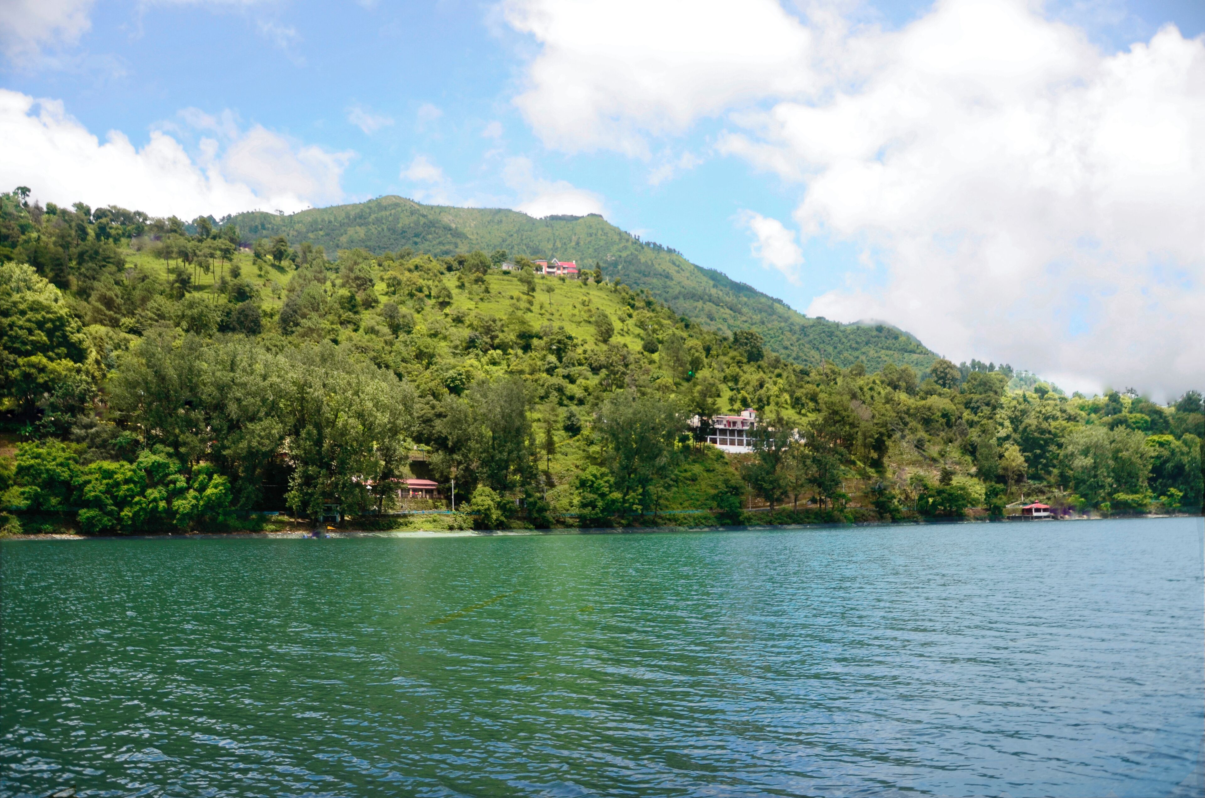Um lago com uma casa numa colina.