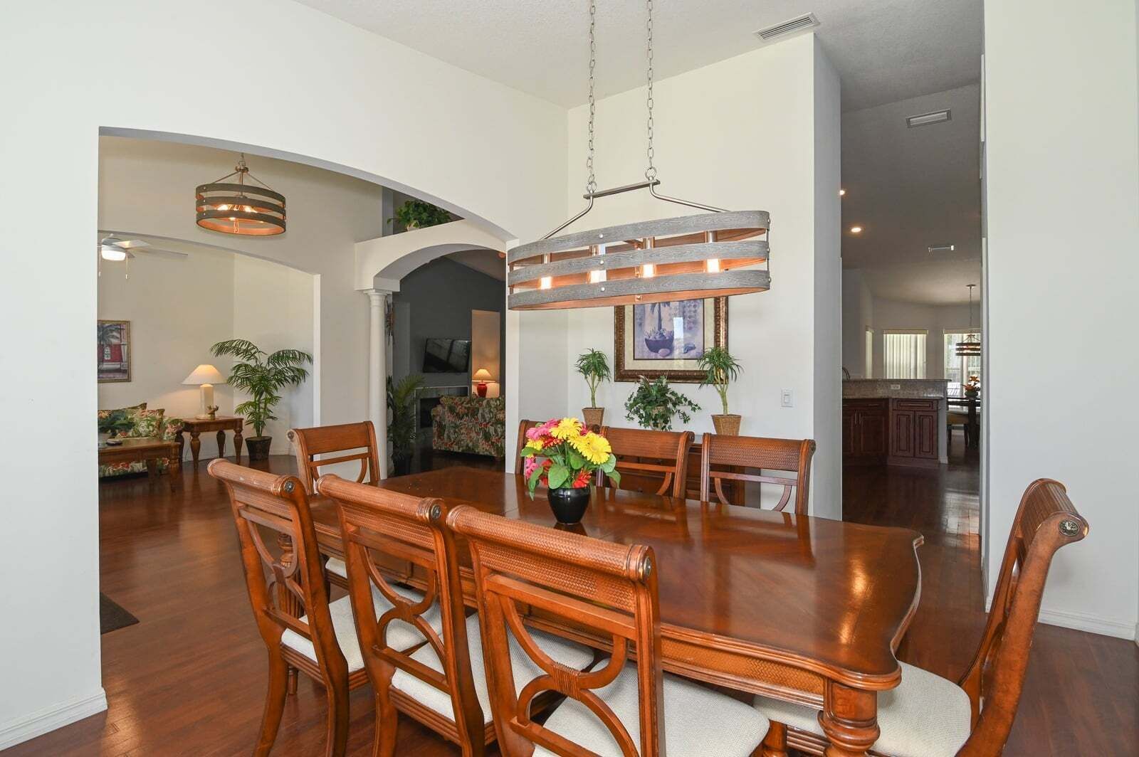 A dining area with a wooden table, chairs, and a hanging light fixture.
