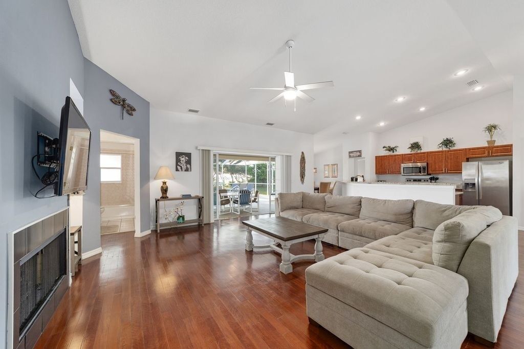 A spacious living room with a fireplace, a large sofa, and a dining area.