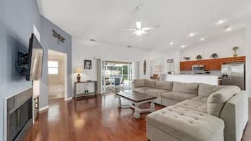 A spacious living room with a fireplace, a large sofa, and a dining area.