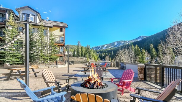 Une terrasse avec des sièges extérieurs, un foyer et une vue sur les montagnes.