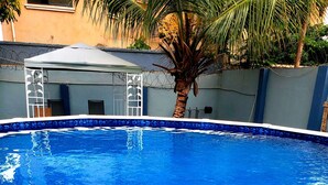 A swimming pool with a white border and a palm tree in the background. - Classy Holiday Villas With Pool in Accra, Ghana (Tema)