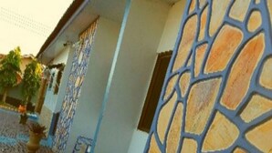 A building with a patterned exterior wall and a paved entrance area. - Classy Holiday Villas With Pool in Accra, Ghana (Tema)