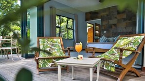A room with a bed, two lounge chairs, a small table with a drink, and a view of the outdoors. - Domaine Desaubin Luxury Villas (Mahé Island)