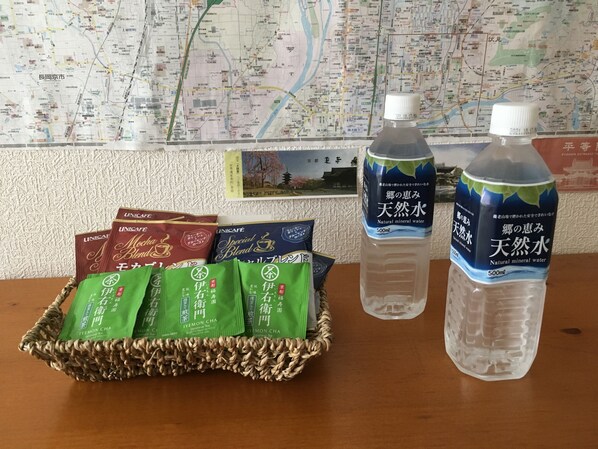 A table with a woven basket containing tea packets, two bottles of water, and a map in the background.