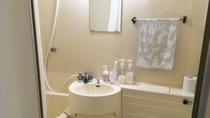 Un baño con lavamanos, espejo, toallero, inodoro y artículos de tocador.