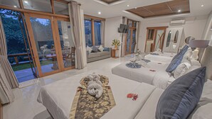 Habitación de hotel con dos camas, un sofá, un televisor y un ventanal grande.