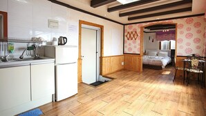 Habitación compacta con kitchenette, una cama y un peque ño rincón de descanso.