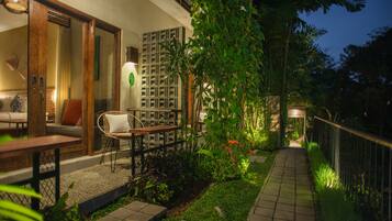Un patio al aire libre con una zona de estar, un camino y un jardín.