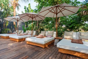 Una piscina al aire libre, sillones reclinables de piscina