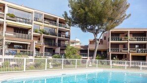 Un edificio moderno con varios balcones y una piscina.
