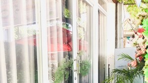 Liukuovi, jonka kautta avautuu näkymä puutarhaan ja taustalla näkyy rakennus.