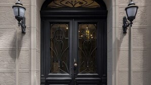 A double door with a decorative arch above it, flanked by two wall-mounted lamps. - Azzap Hotel Galata (Istanbul)