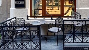 A hotel entrance with a large arched doorway, a sign reading "AZZAP HOTEL," and outdoor seating with metal chairs and tables. - Azzap Hotel Galata (Istanbul)