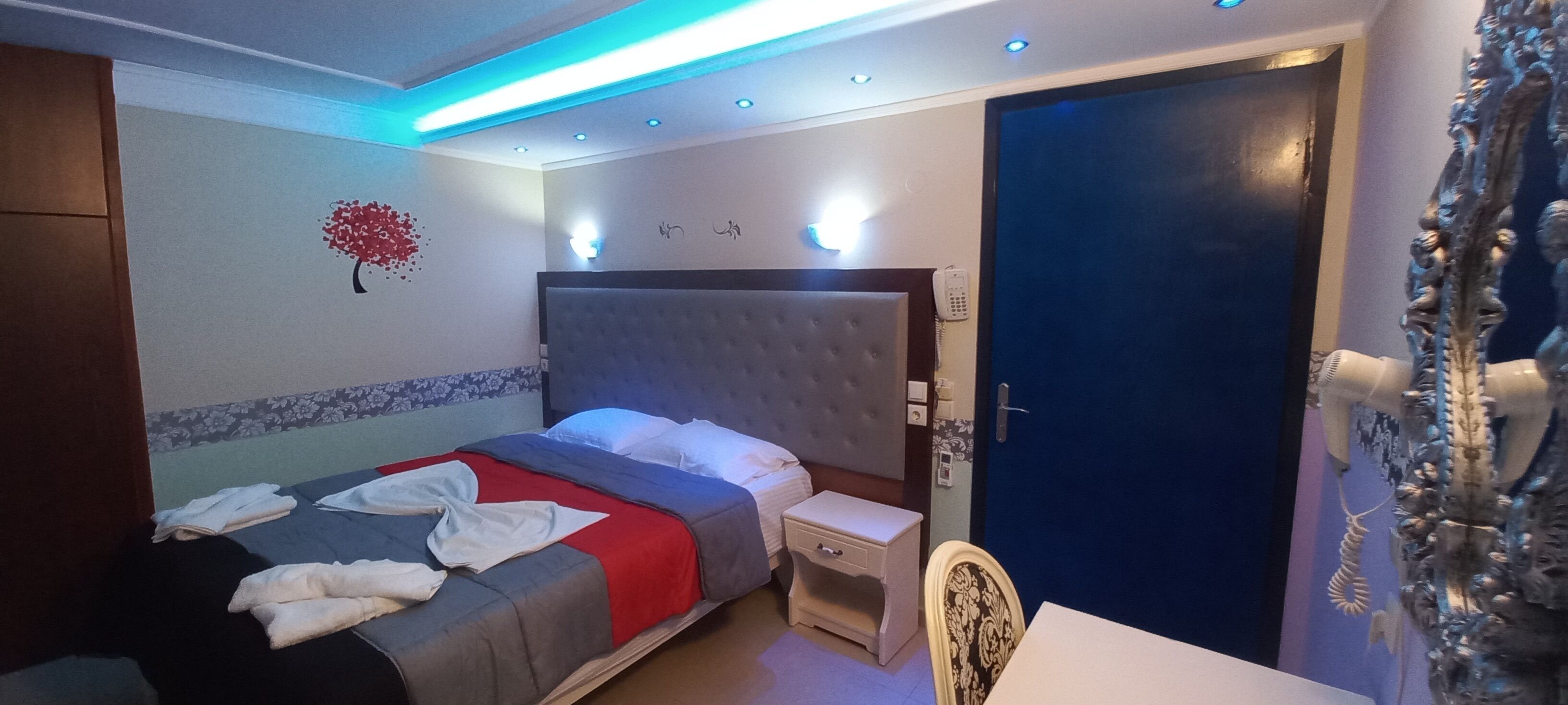 Een slaapkamer met een bed, nachtkastje en een deur.