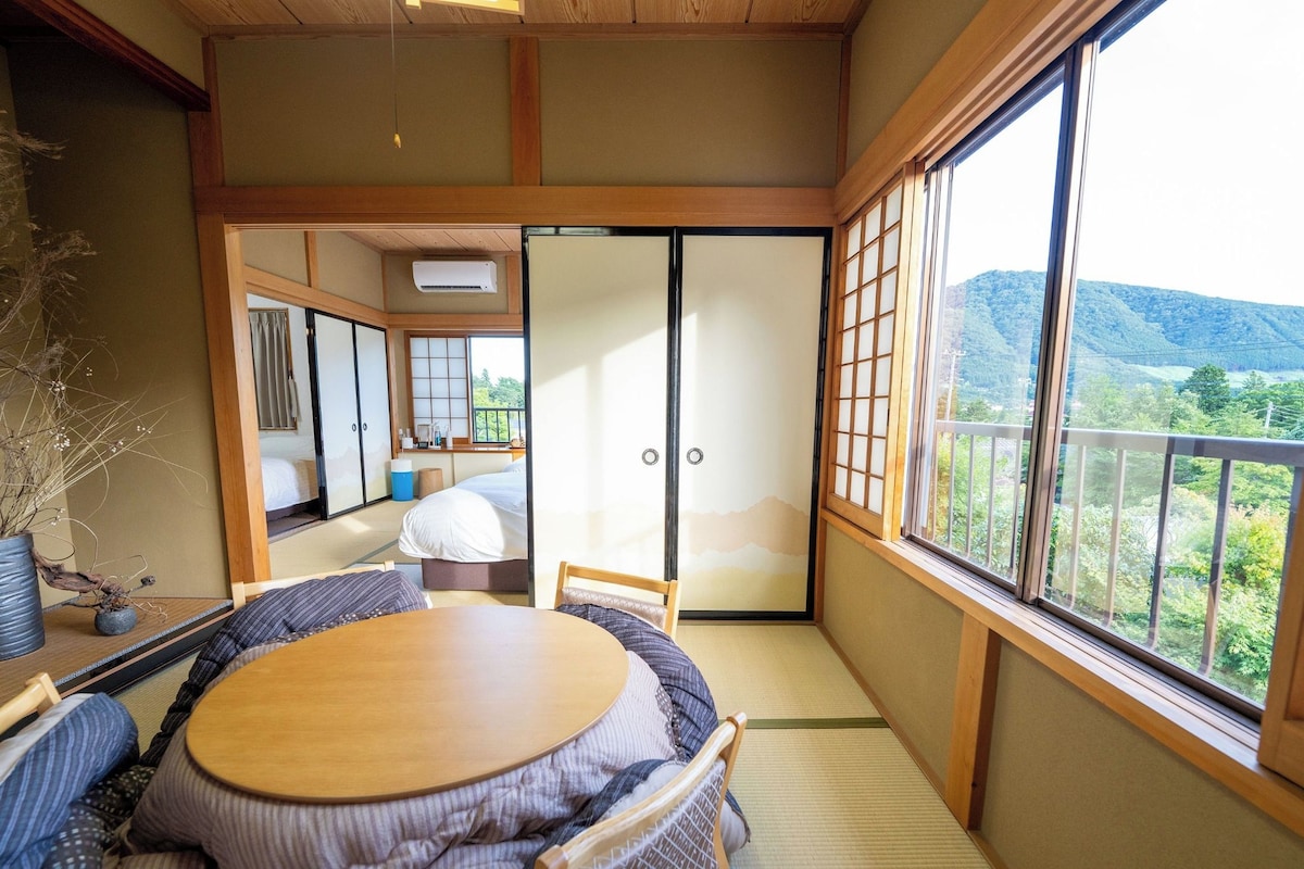 Een traditionele Japanse kamer met tatami vloerbedekking, een lage tafel en schuifdeuren.