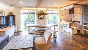 A modern kitchen with wooden countertops, a dining table, and a built-in oven. - Springs Village Hakone Glamping Resort (Hakone)