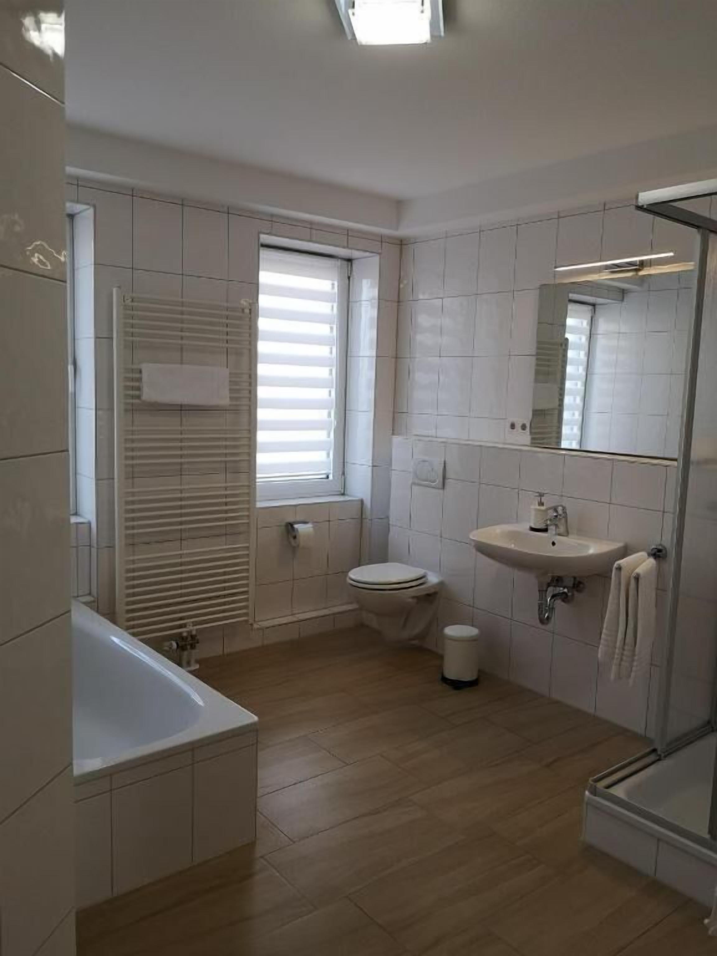Een moderne badkamer met toilet, wastafel en bad.