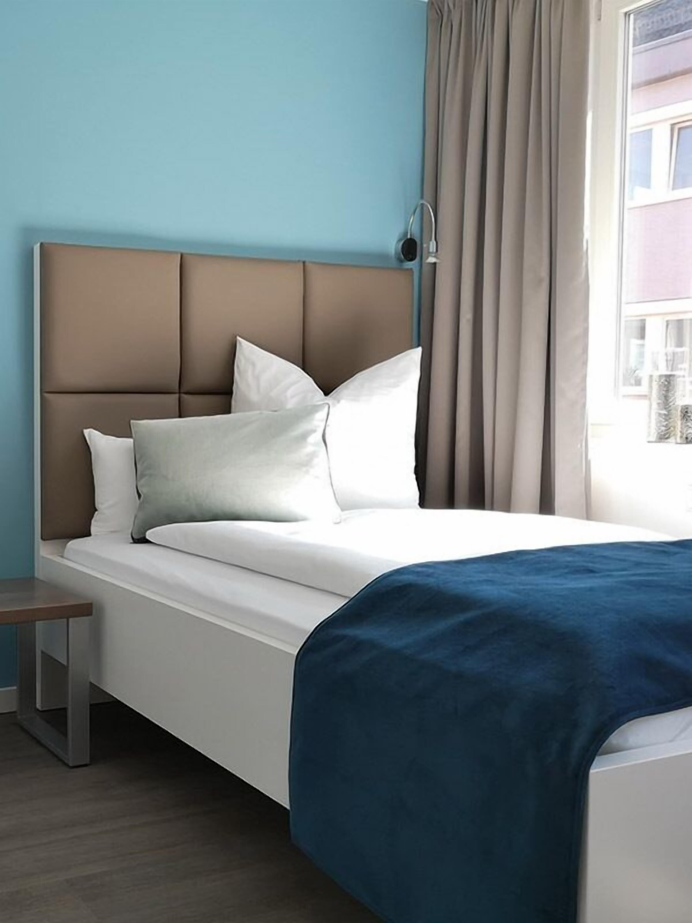 Hypo-allergenic bedding, desk, laptop workspace, blackout drapes