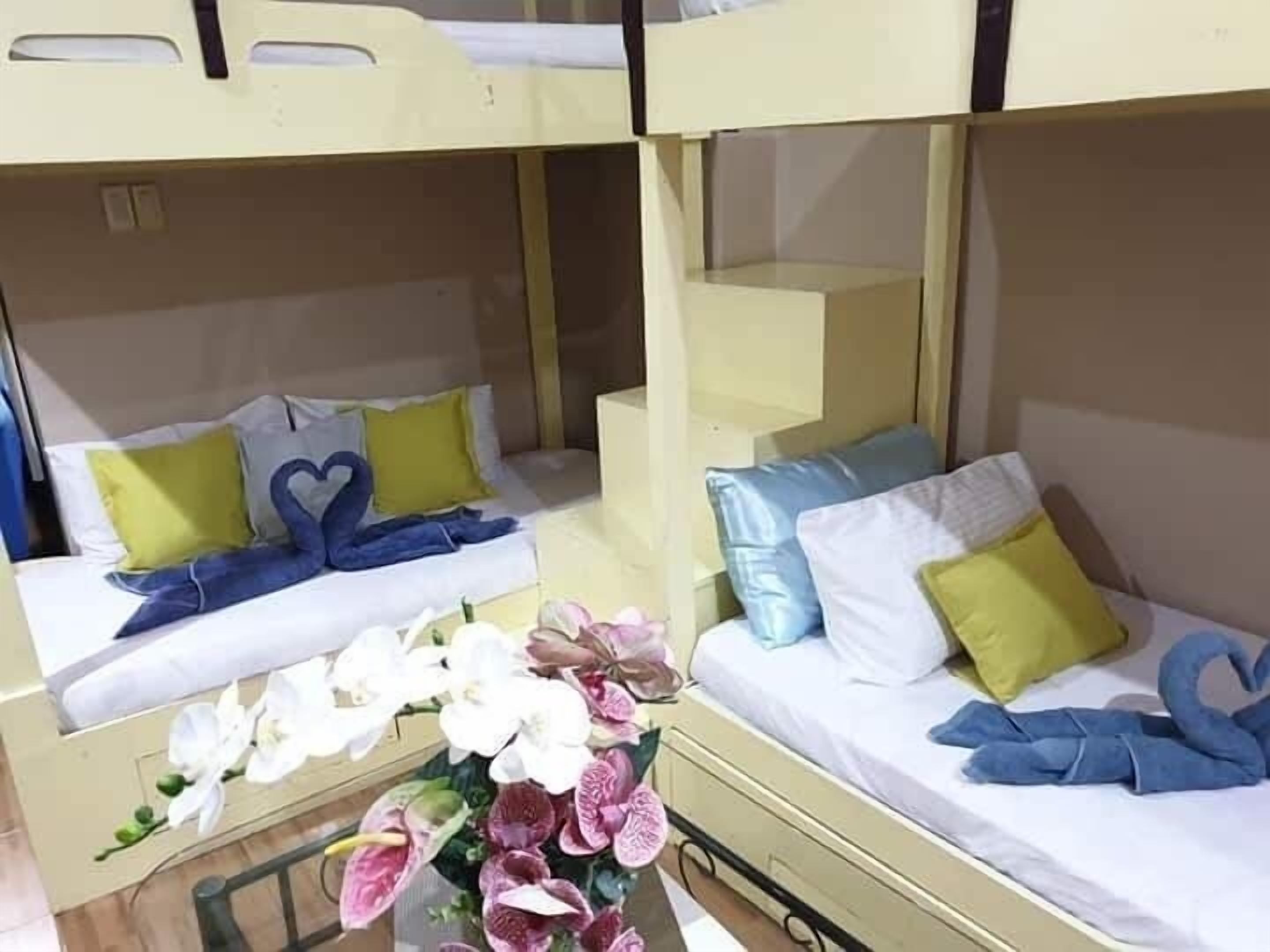 A bunk bed room with two beds, each with pillows and a heart-shaped towel.