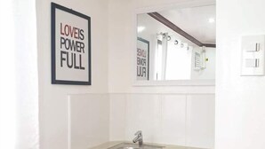 A bathroom with a sink, mirror, and a motivational poster on the wall. - Palompon Traveler's Lodge (Palompon)