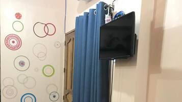 Ein Essbereich mit einem Glastisch, schwarzen Stühlen, einem Holzschrank mit Schubladen und einer Wand mit kreisförmigen Mustern.