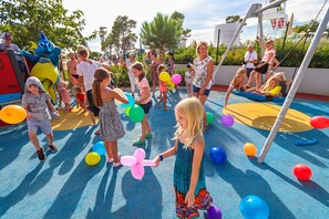 Ein Spielplatz mit spielenden Kindern und Luftballons.