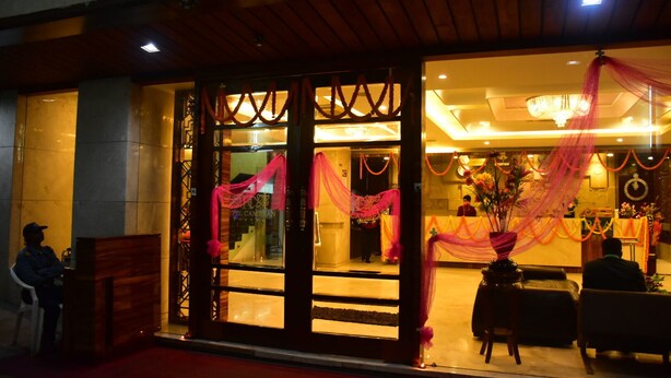 A hotel entrance with a reception desk, a chandelier, and a red carpet. - Hotel Cambean (Durg)