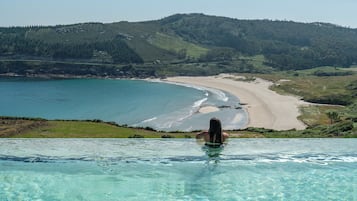 Una piscina al aire libre, sillones reclinables de piscina