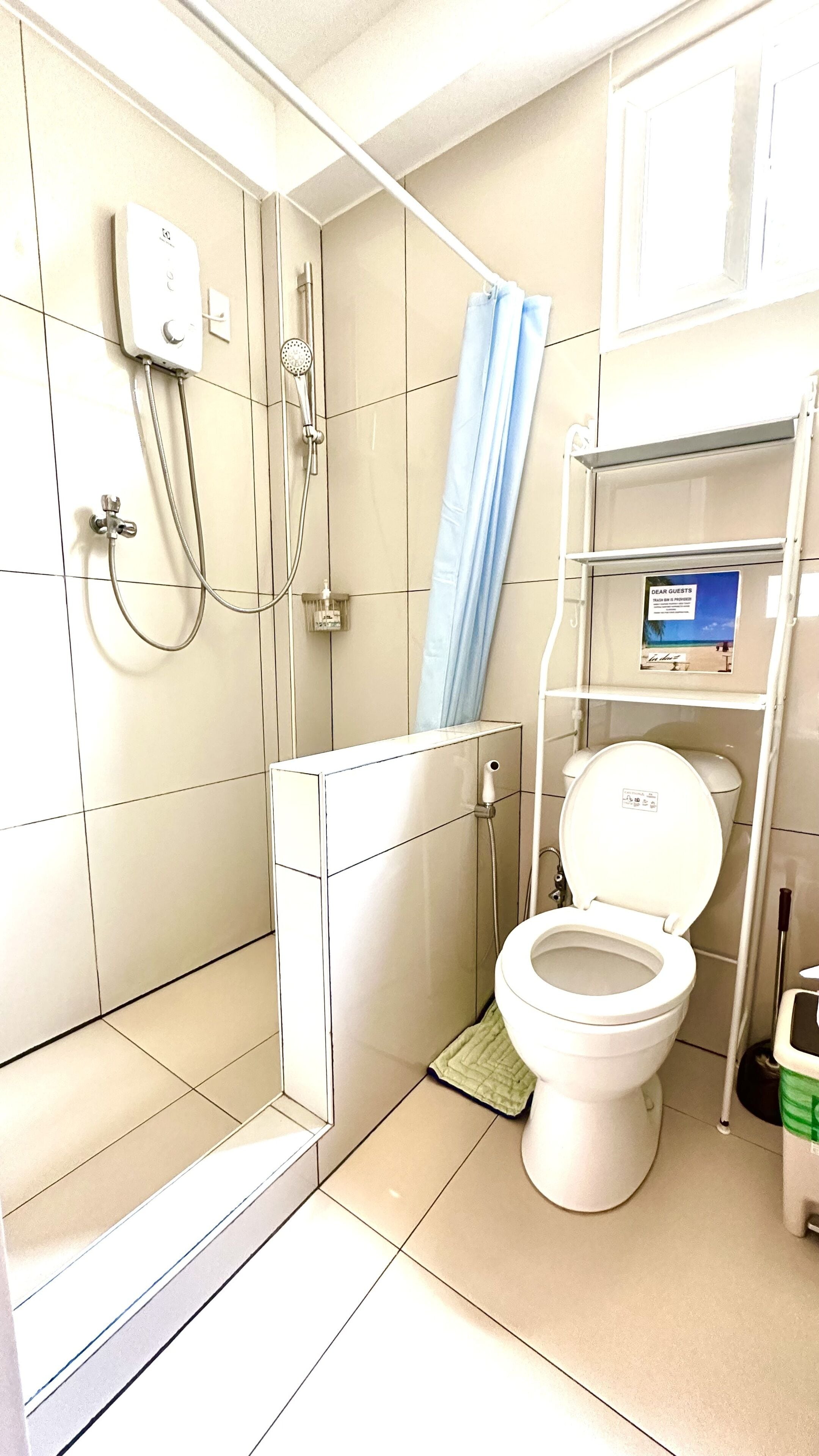 Une salle de bain équipée d’une douche, de toilettes et d’une étagère sur laquelle se trouve un appareil numérique.