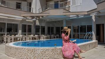 Seasonal outdoor pool, open 11:00 AM to 9:00 PM, pool loungers