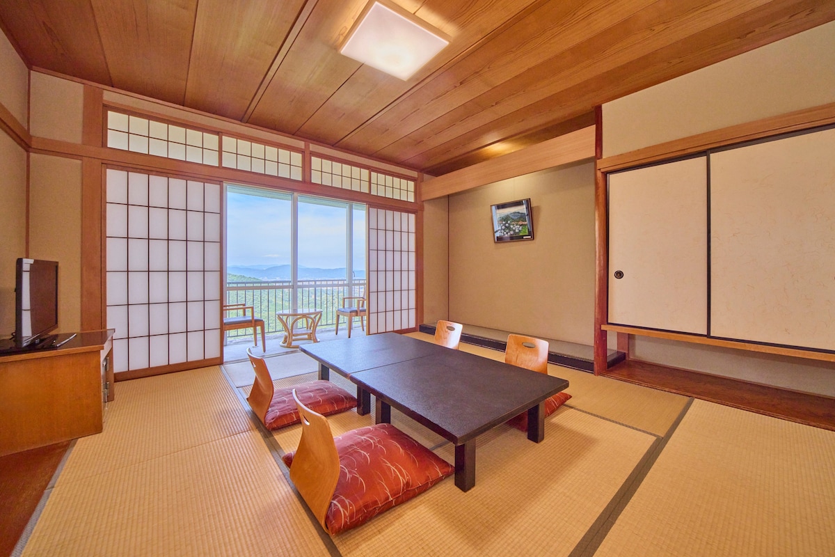 Una habitación japonesa tradicional con suelo de tatami, una mesa baja y puertas correderas.